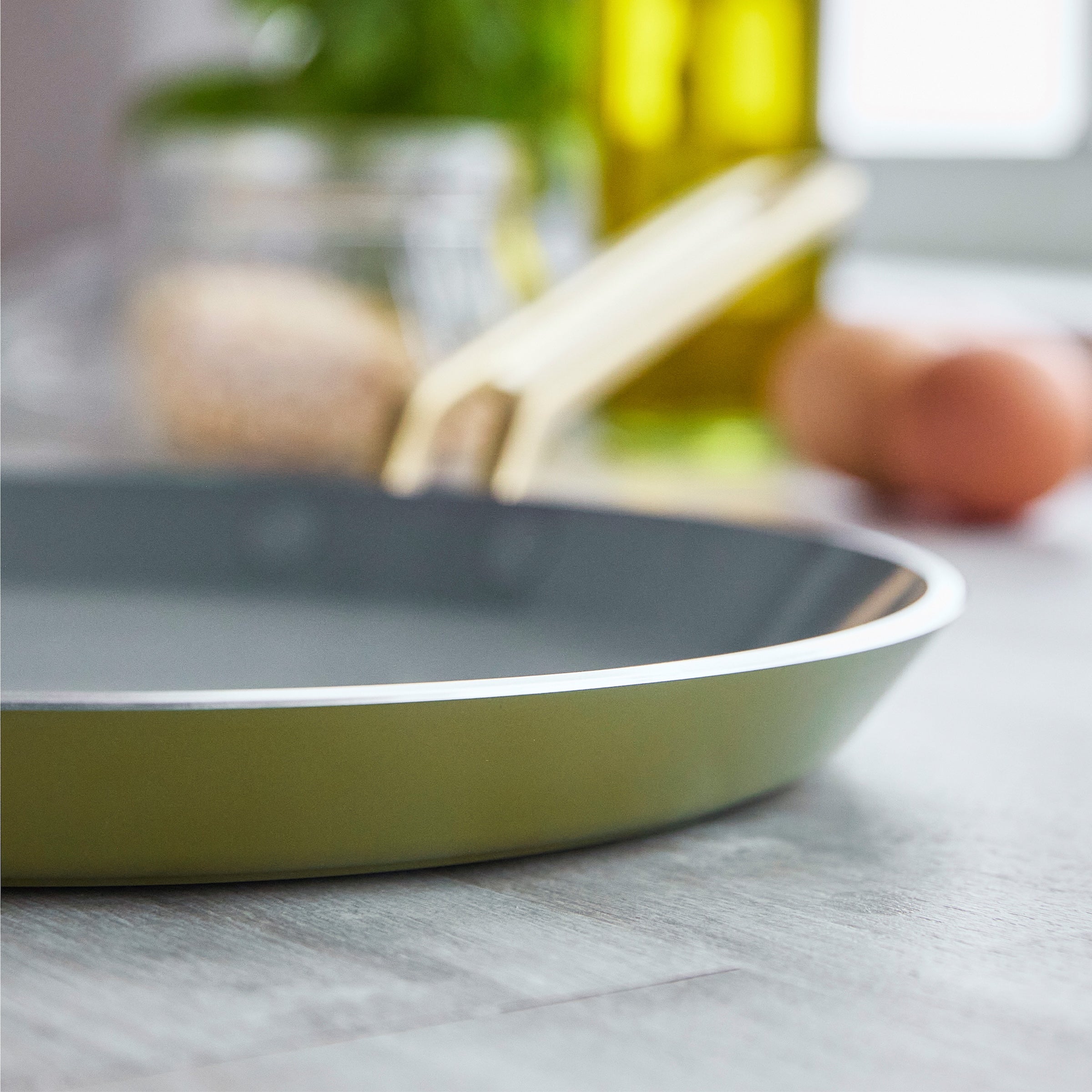 Green crepe pan on a kitchen counter with blurred background