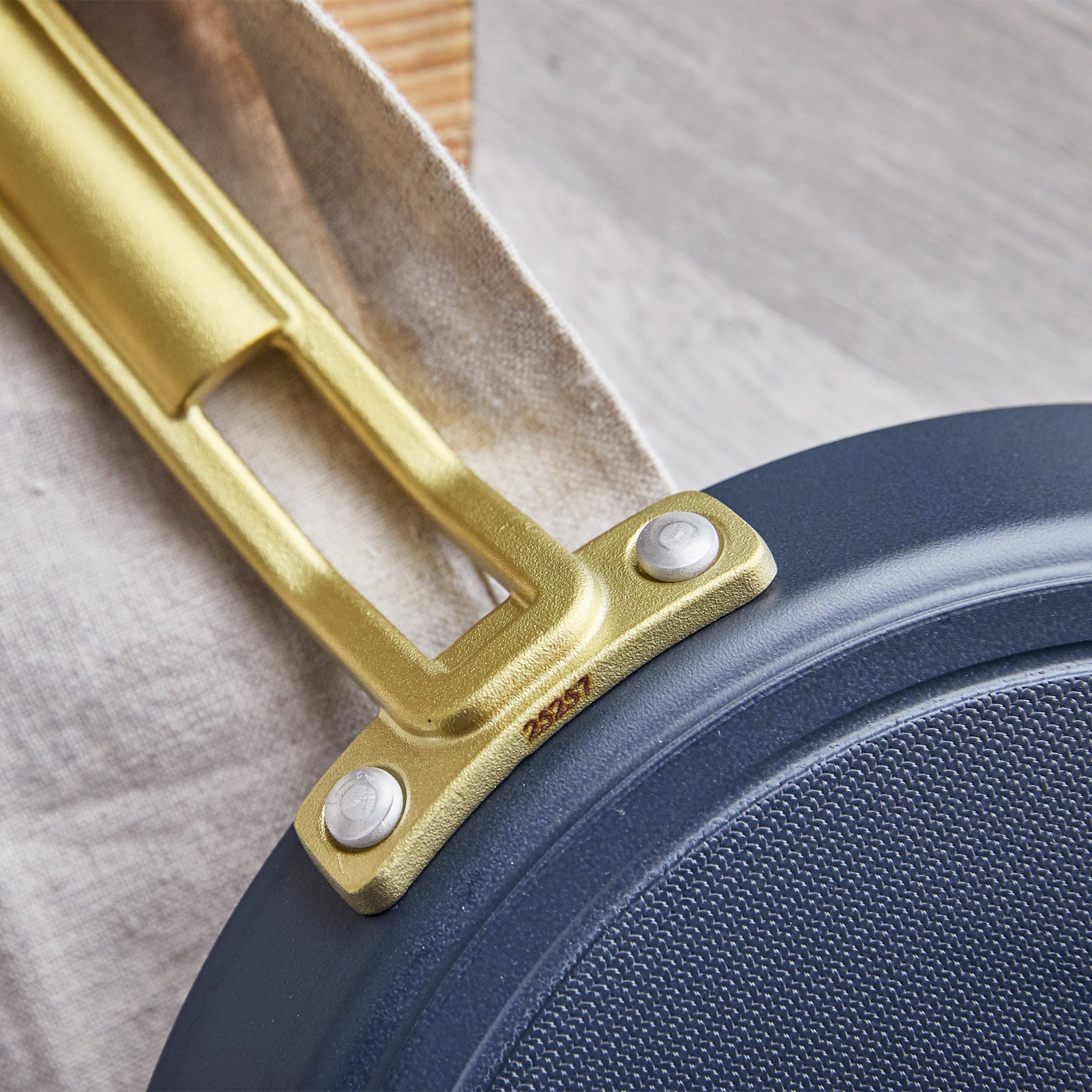 Close-up of a blue crepe pan with a gold handle