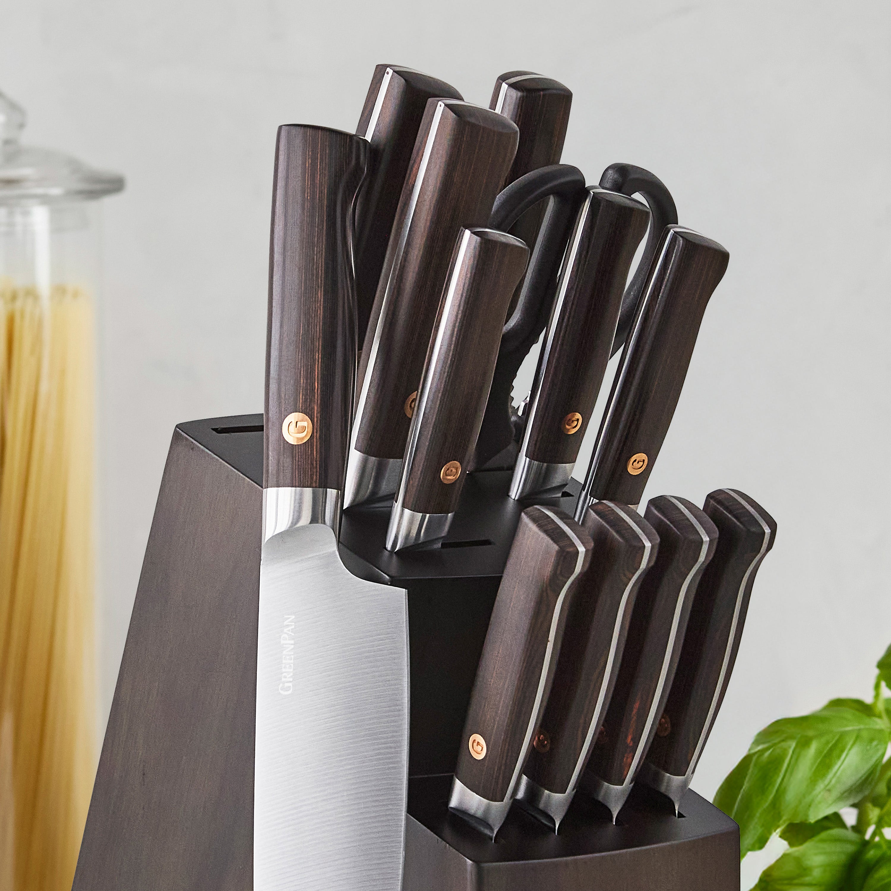 Set of knives in a knife block on a light gray background.