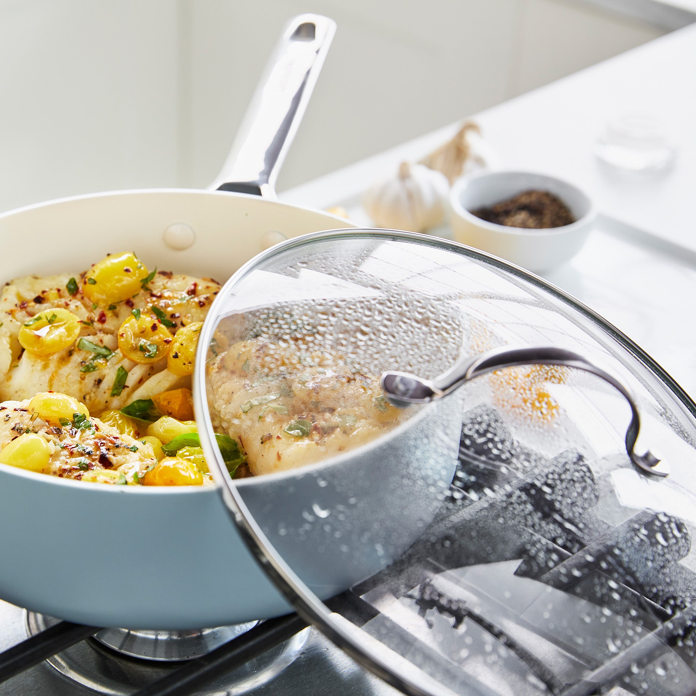 Cooking scene with a pot on a stove and a covered dish, featuring food.