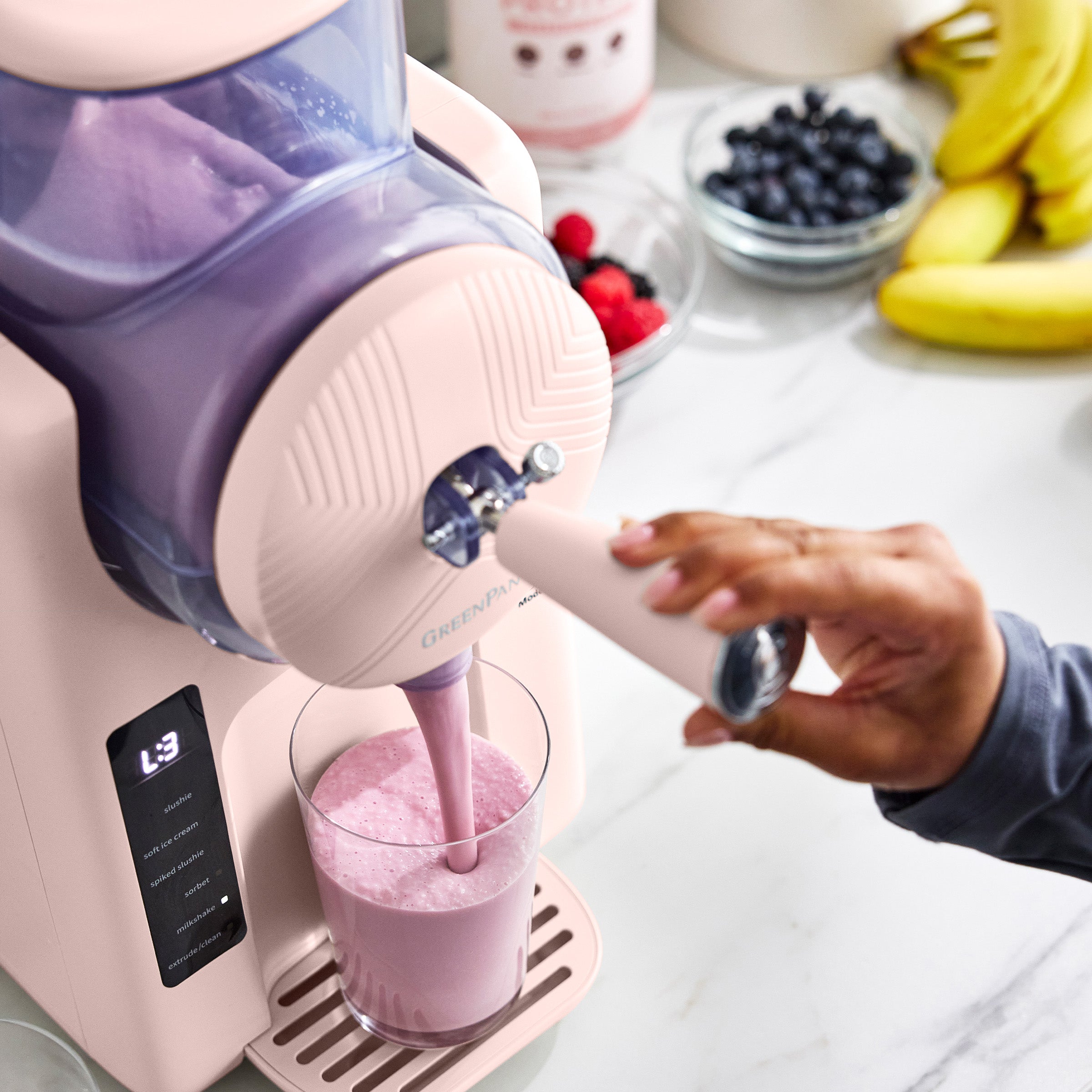 Pink ice cream maker pouring a smoothie into a glass 