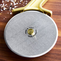 Close-up of a pizza cutter with 'Made in Italy' stamp on a wooden surface