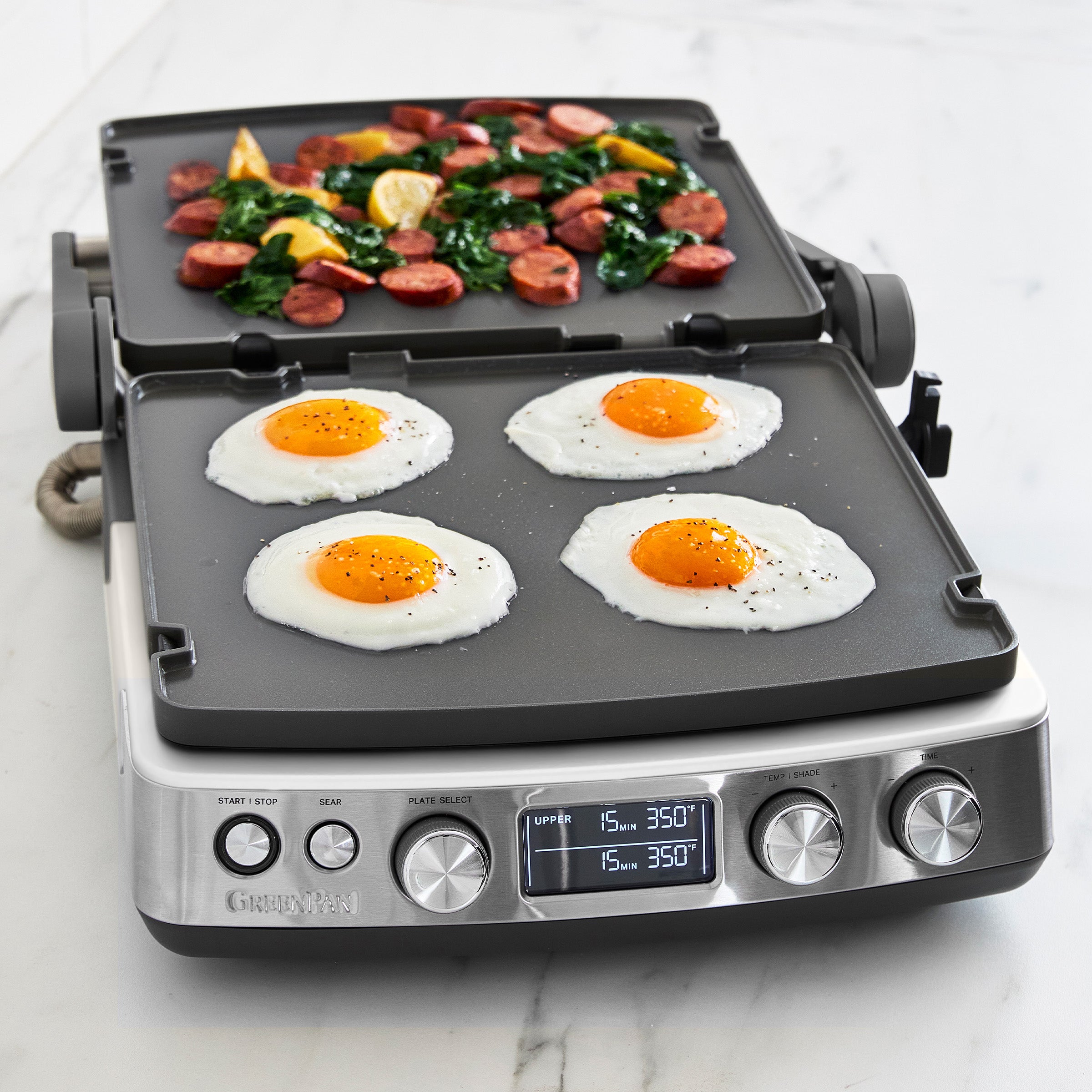 Multifunctional cooking appliance with griddle plates showing eggs and meat on a white background