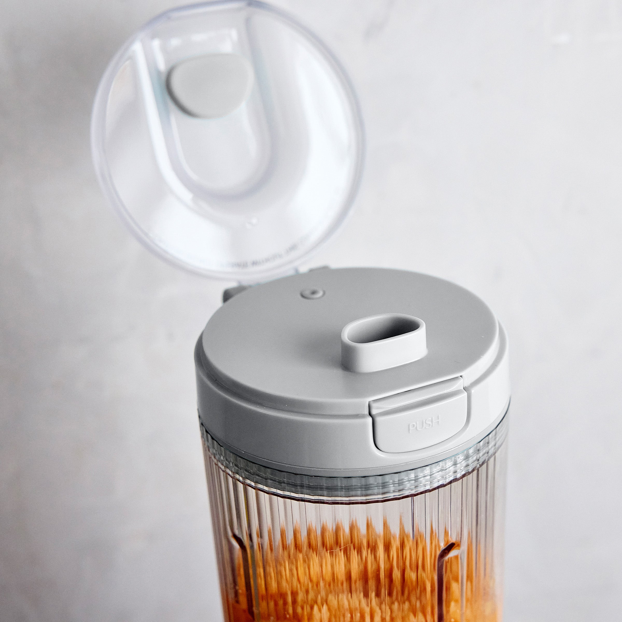 Gray portable blender with a lid on a white background