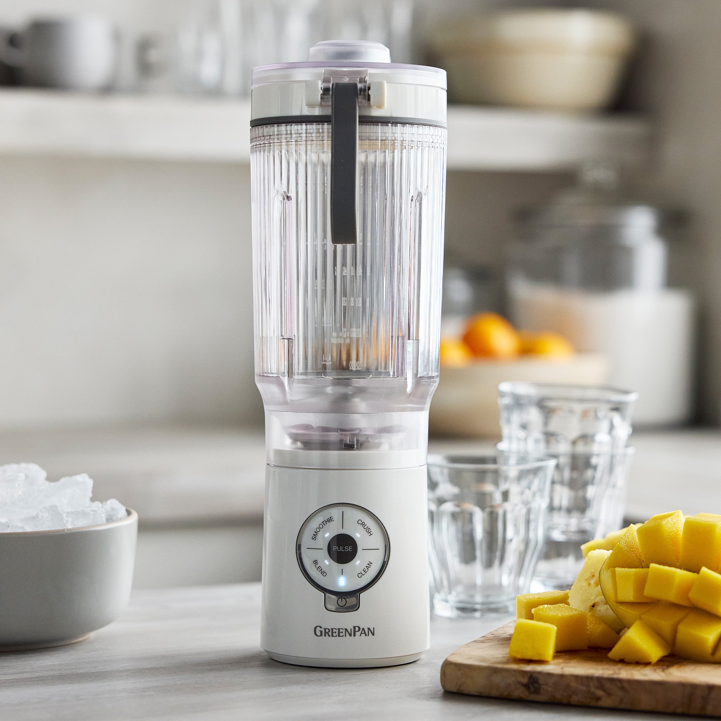 White blender with clear container on a kitchen counter with ingredients