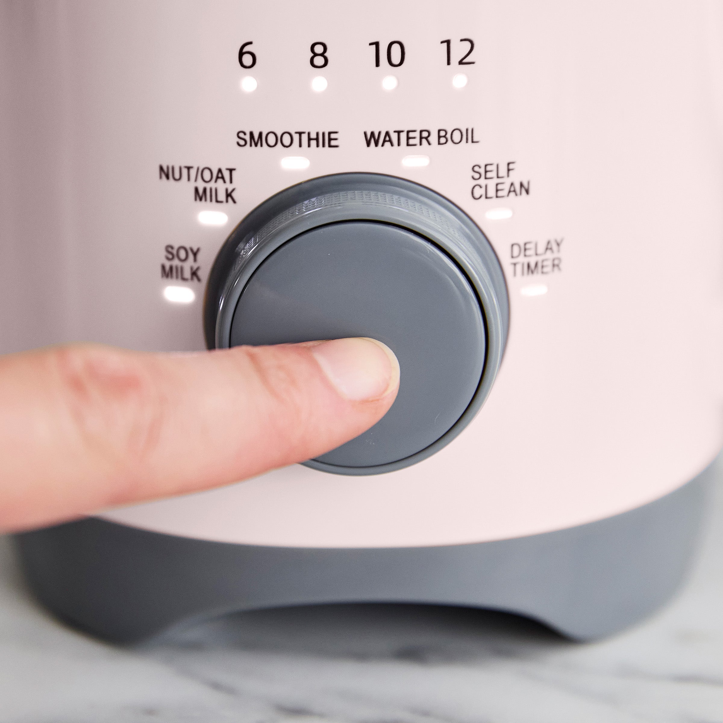 Person pressing a button on an appliance with various settings labeled.