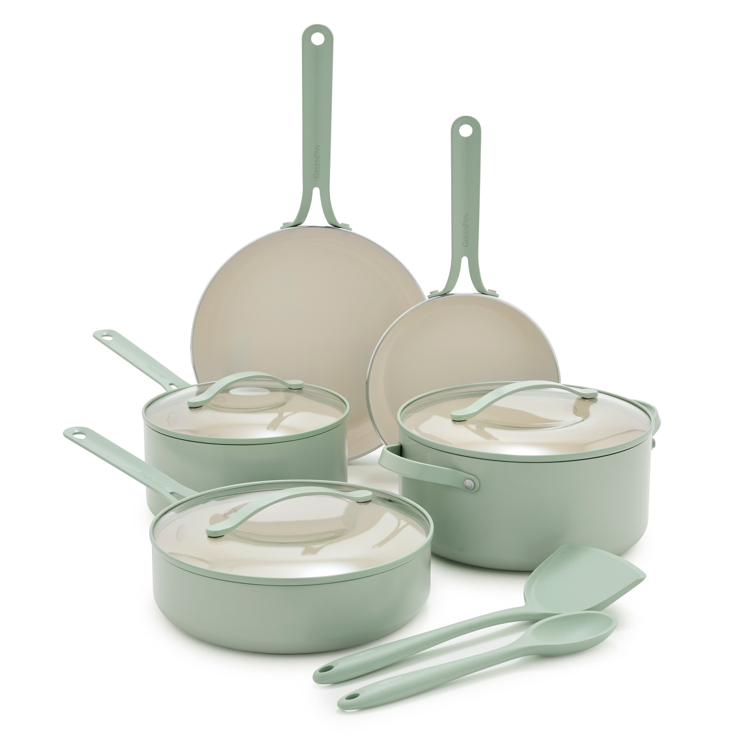 Set of green cookware with lids and a utensils on a white background