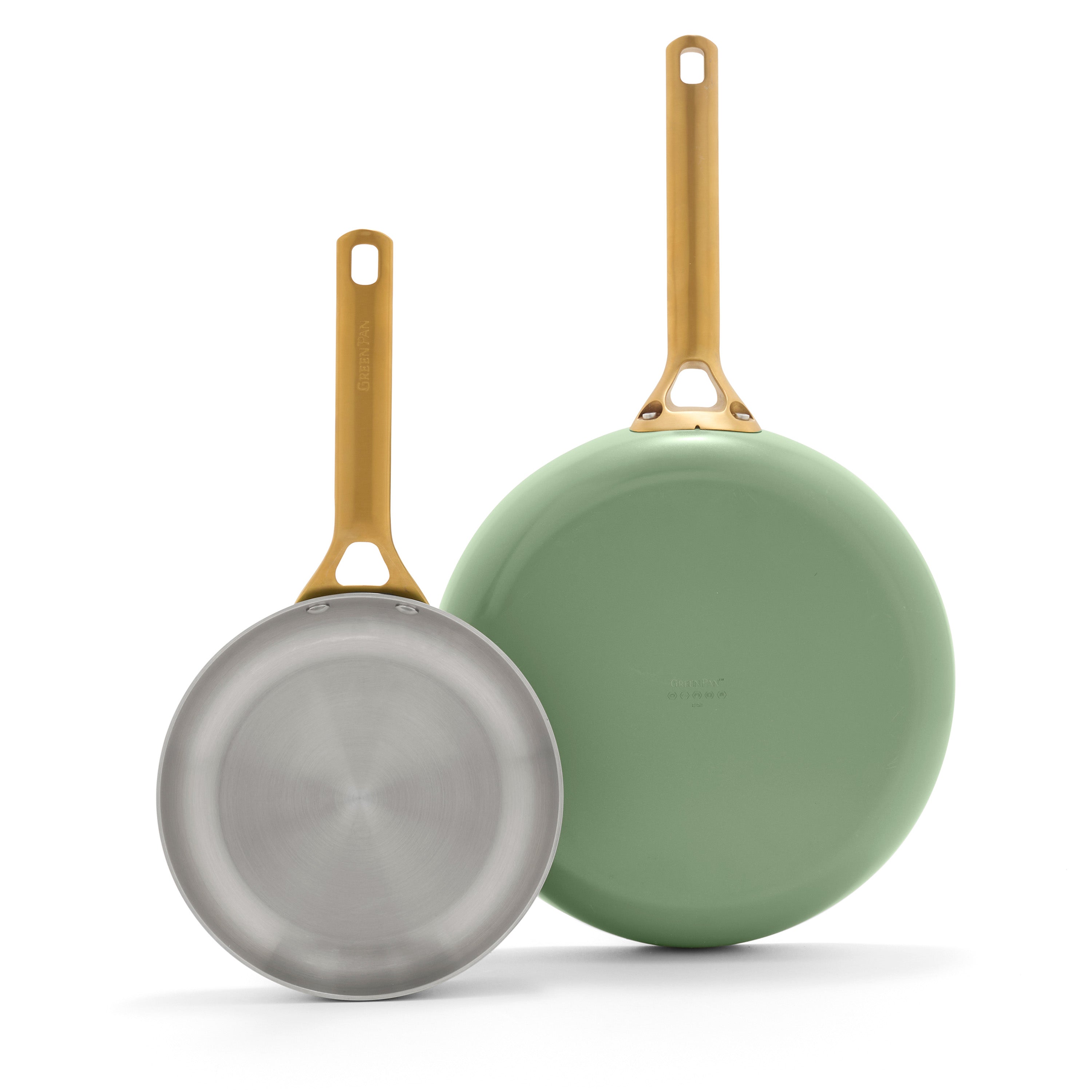 Two frying pans with gold handles on a white background