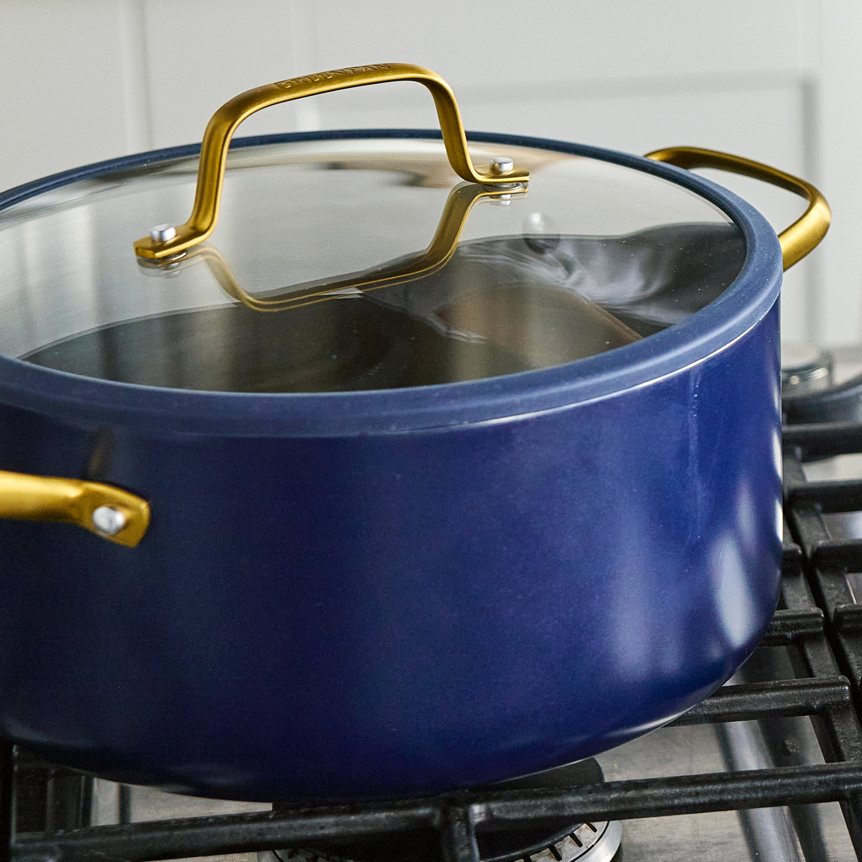 Blue pot with gold handles on a stove