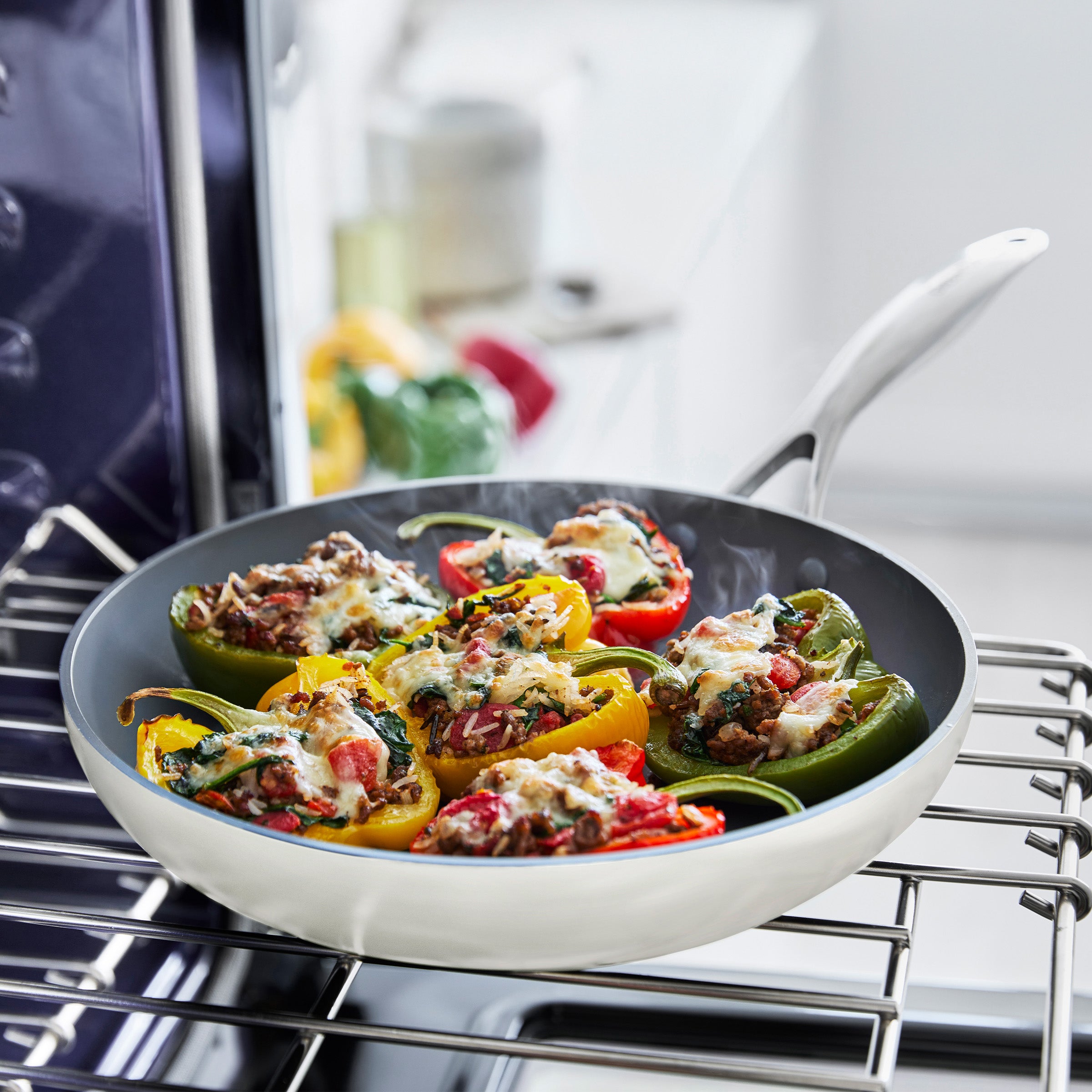 Stuffed bell peppers in a cream frypan on an oven rack