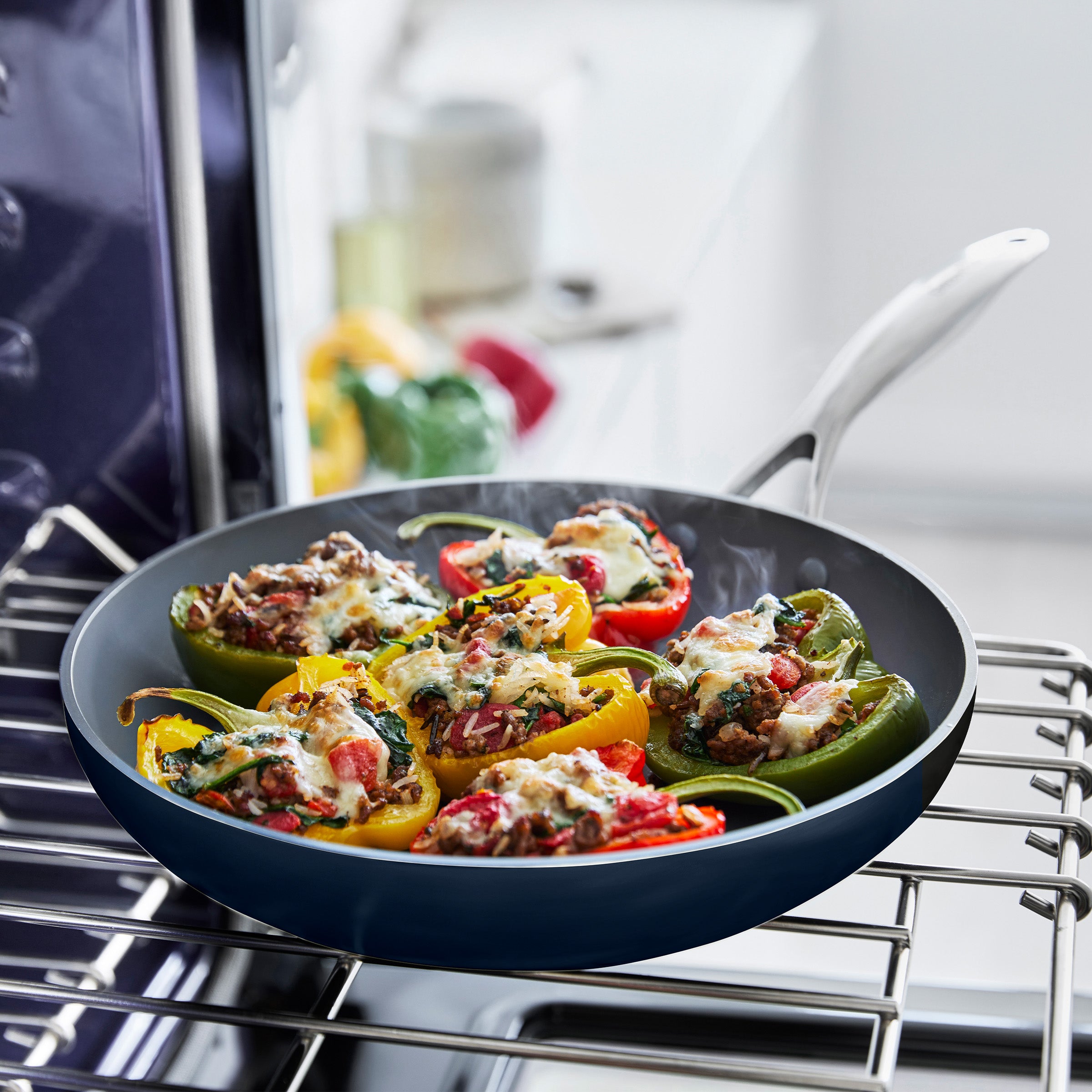 Stuffed bell peppers in a cream frypan on an oven rack