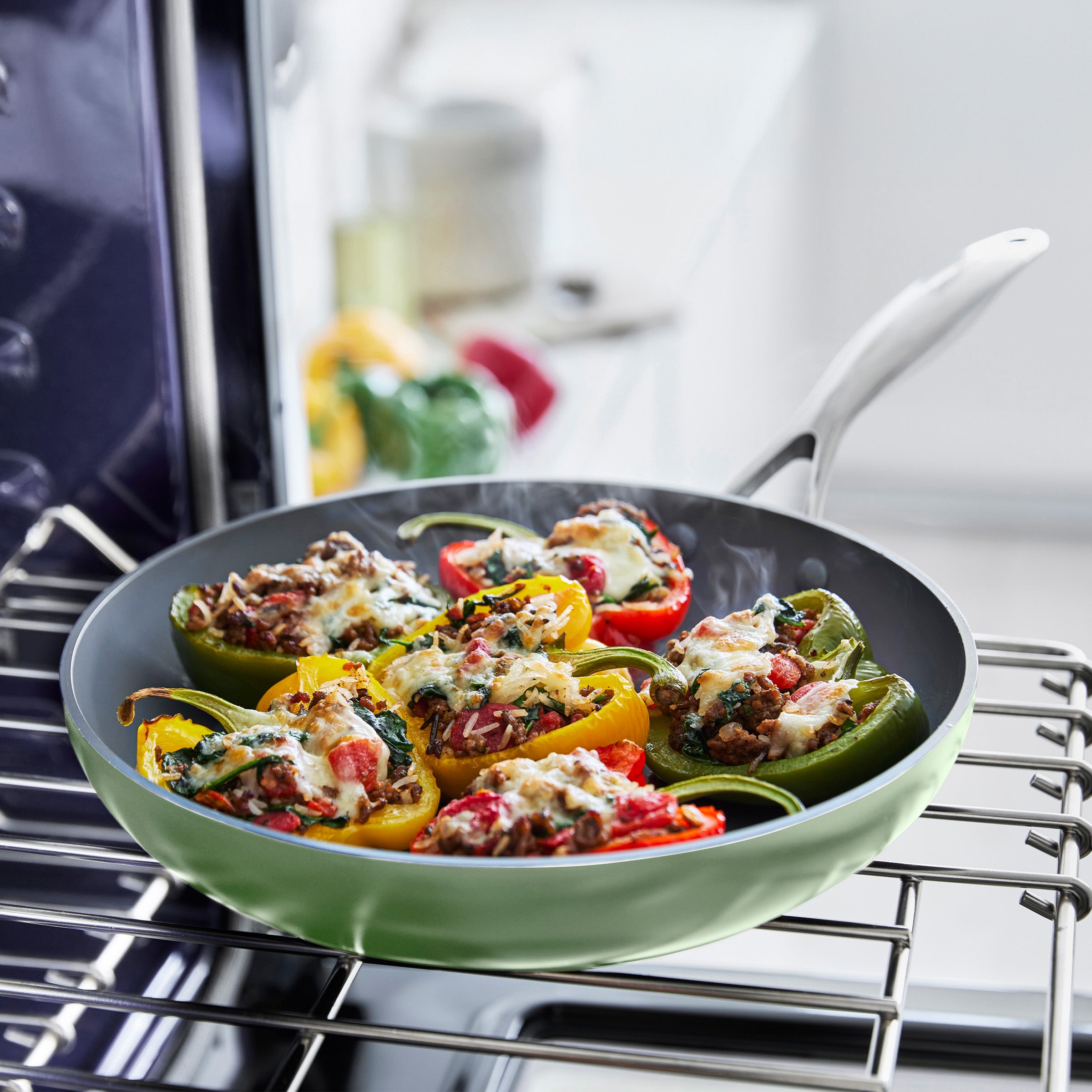 Stuffed bell peppers in a cream frypan on an oven rack
