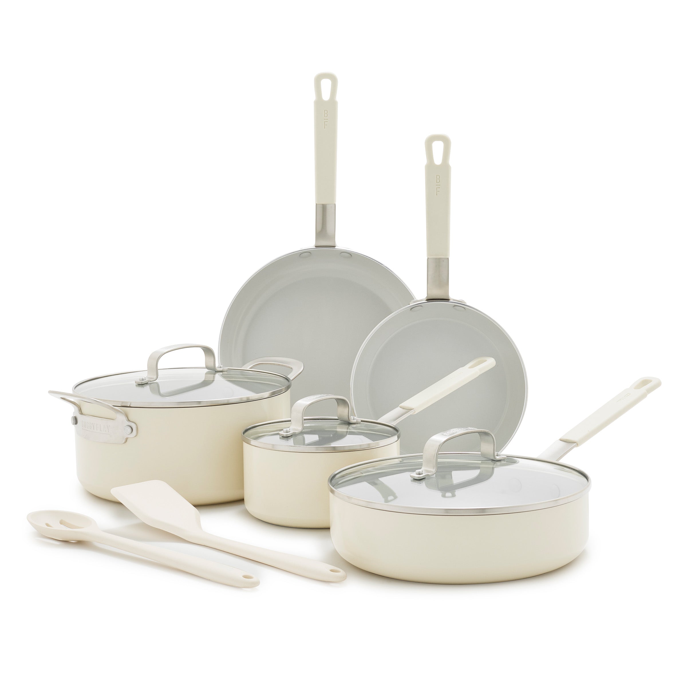 Cream ceramic 10-piece cookware set with 2 pans, 3 pots with lids, and 2 utensils arranged together.