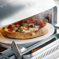 Stainless steel pizza oven with a pizza on a pizza stone inside