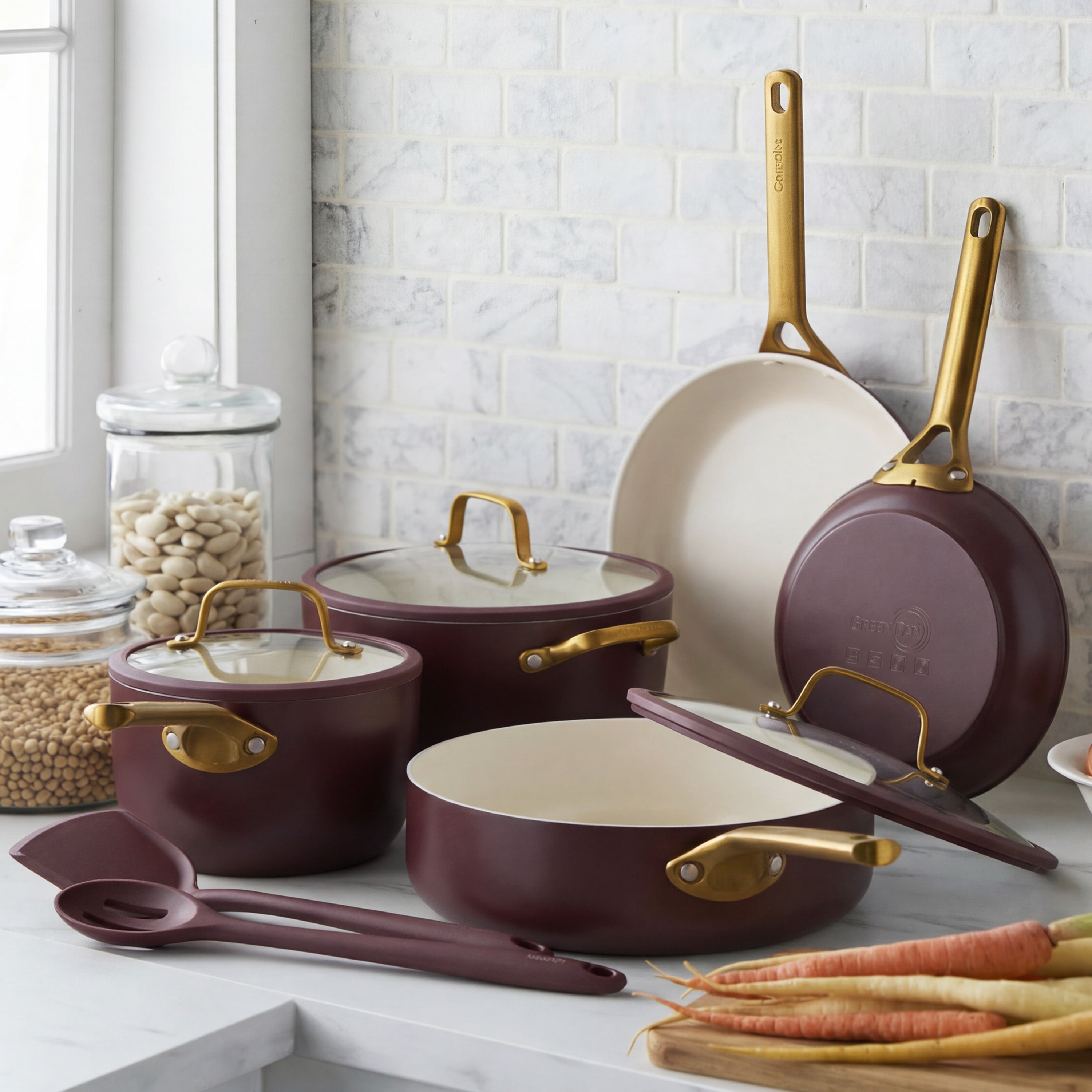 Bordeaux ceramic nonstick cookware set, 10 pieces, displayed on a kitchen counter with jars of beans and carrots nearby.