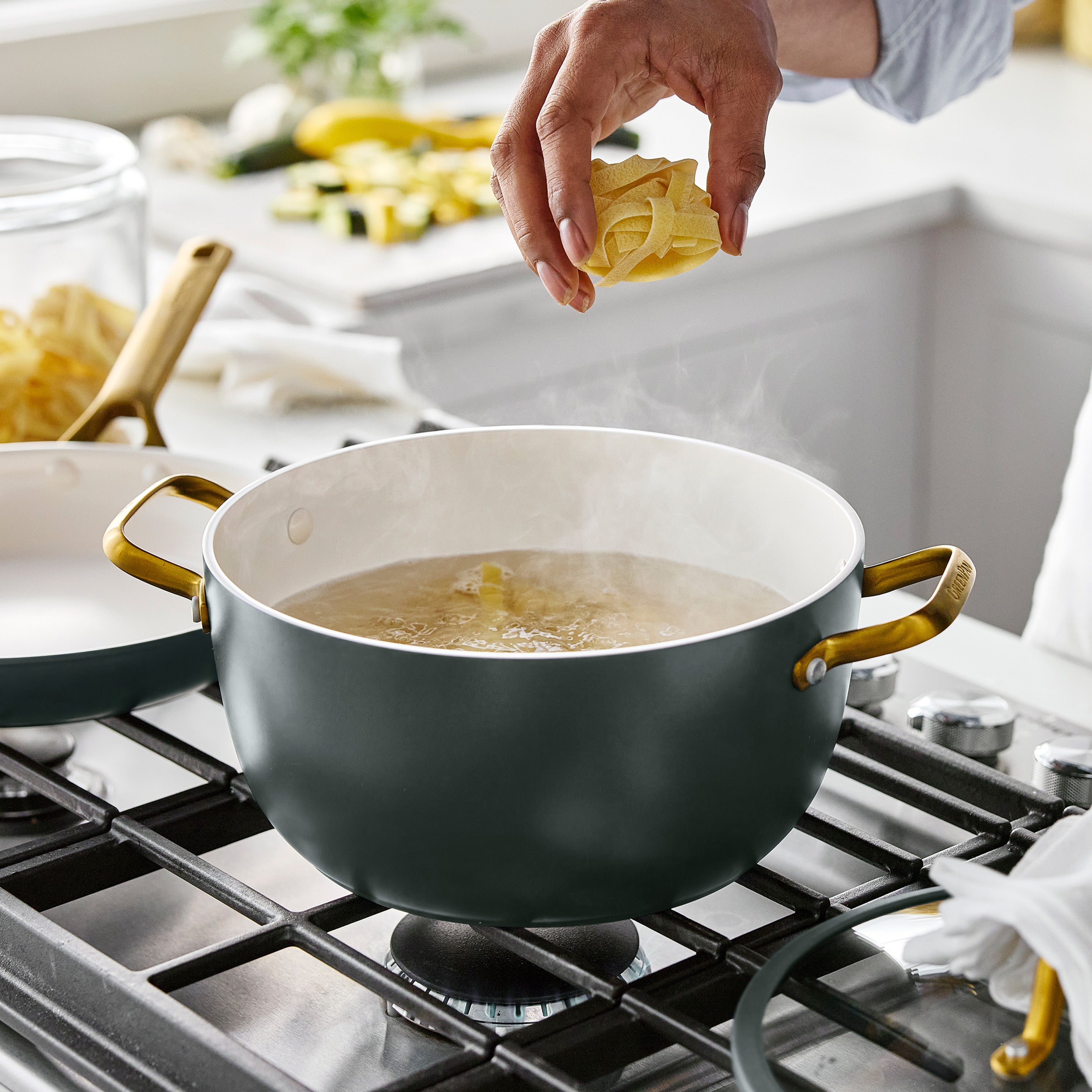 Boiling pasta in a Reserve Pro ceramic nonstick pot from a 10-piece set on a stove in a bright kitchen.