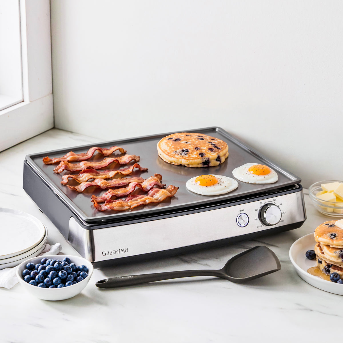 Ultimate Countertop Griddle in graphite cooking bacon, eggs, and a blueberry pancake.