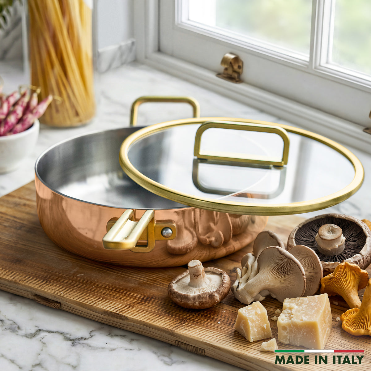Copper 4-quart sauté pan with lid on a counter near mushrooms and cheese, window in background, “Made in Italy” text in corner.