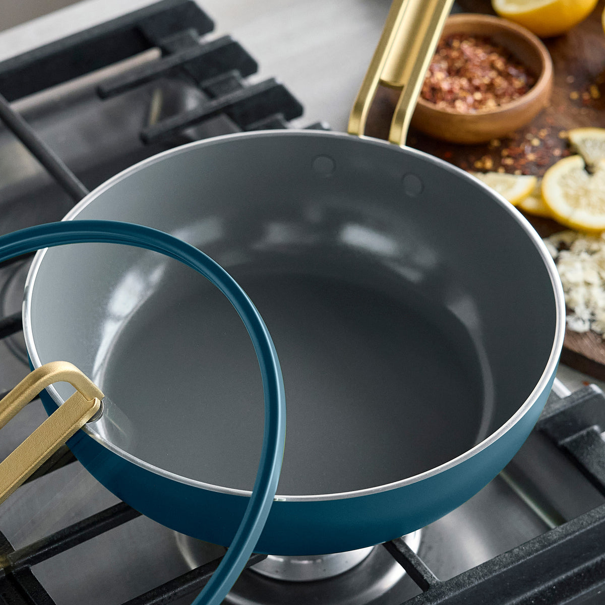 Stanley Tucci 3.25-quart ceramic nonstick Piccolo pan in Venetian Teal with a light gray interior, gold handle, and lid.