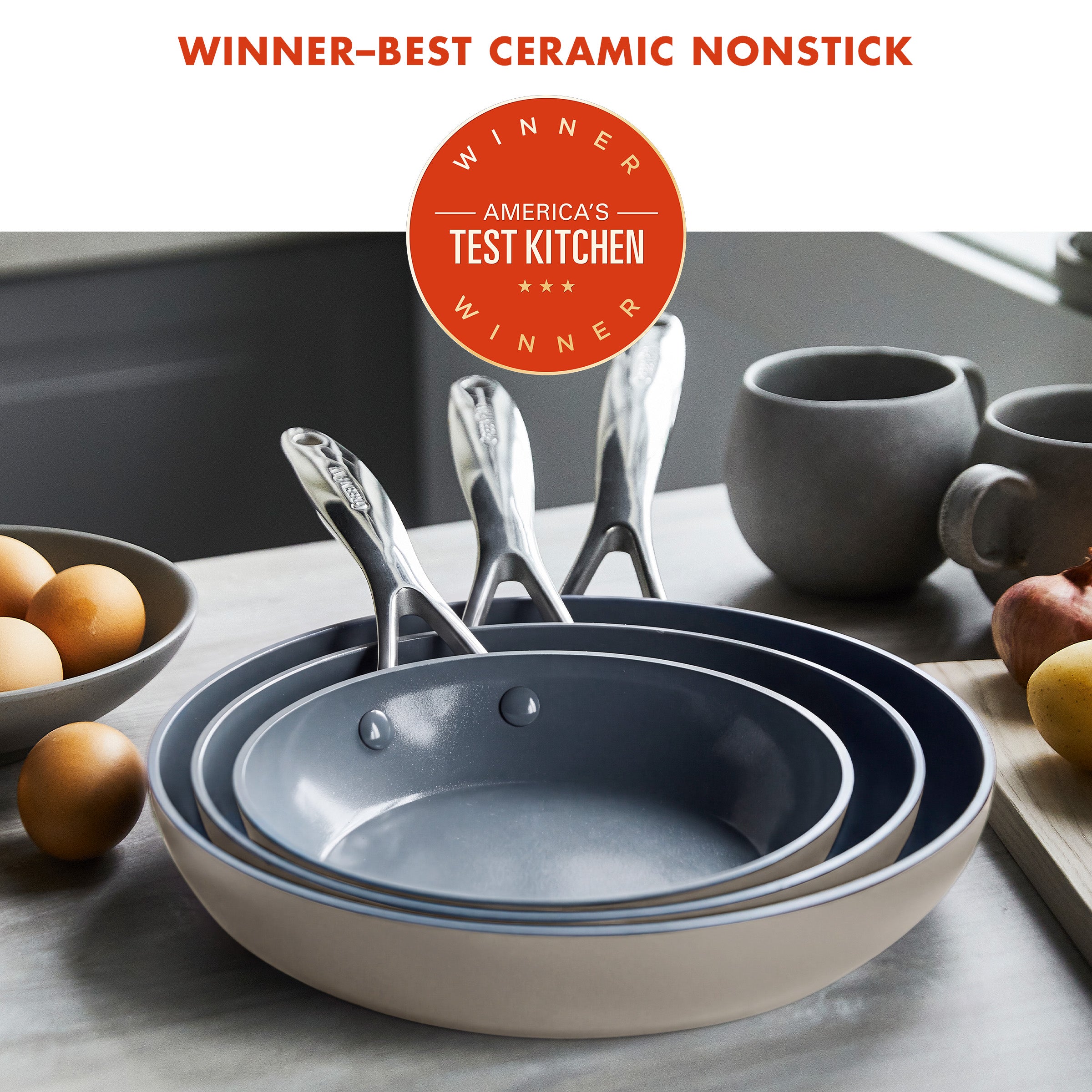 Set of three taupe ceramic nonstick frying pans, 8, 9.5, and 11, stacked on a kitchen counter.