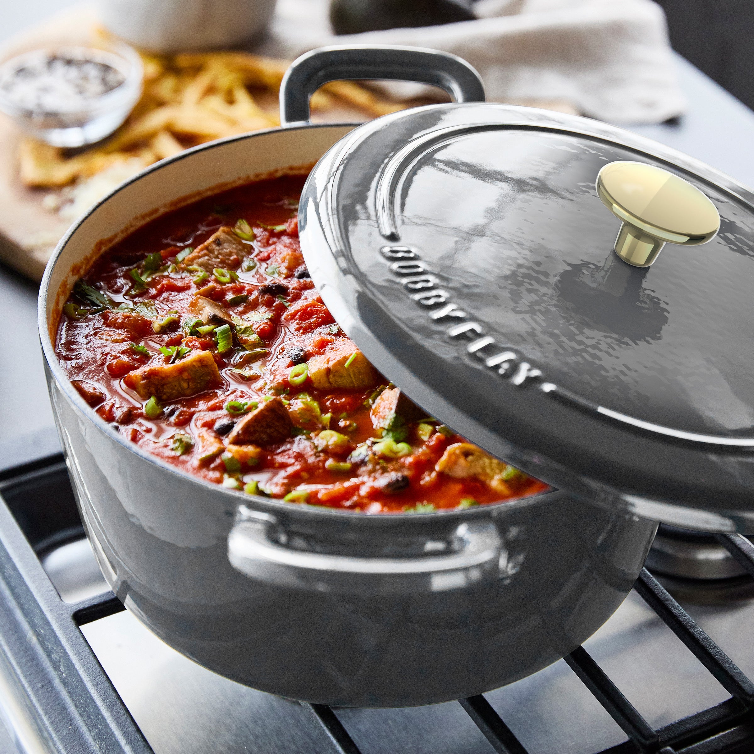 Slate-colored Dutch oven set with lid and handles, 5.5-quart size, ceramic material, shown on a kitchen surface.