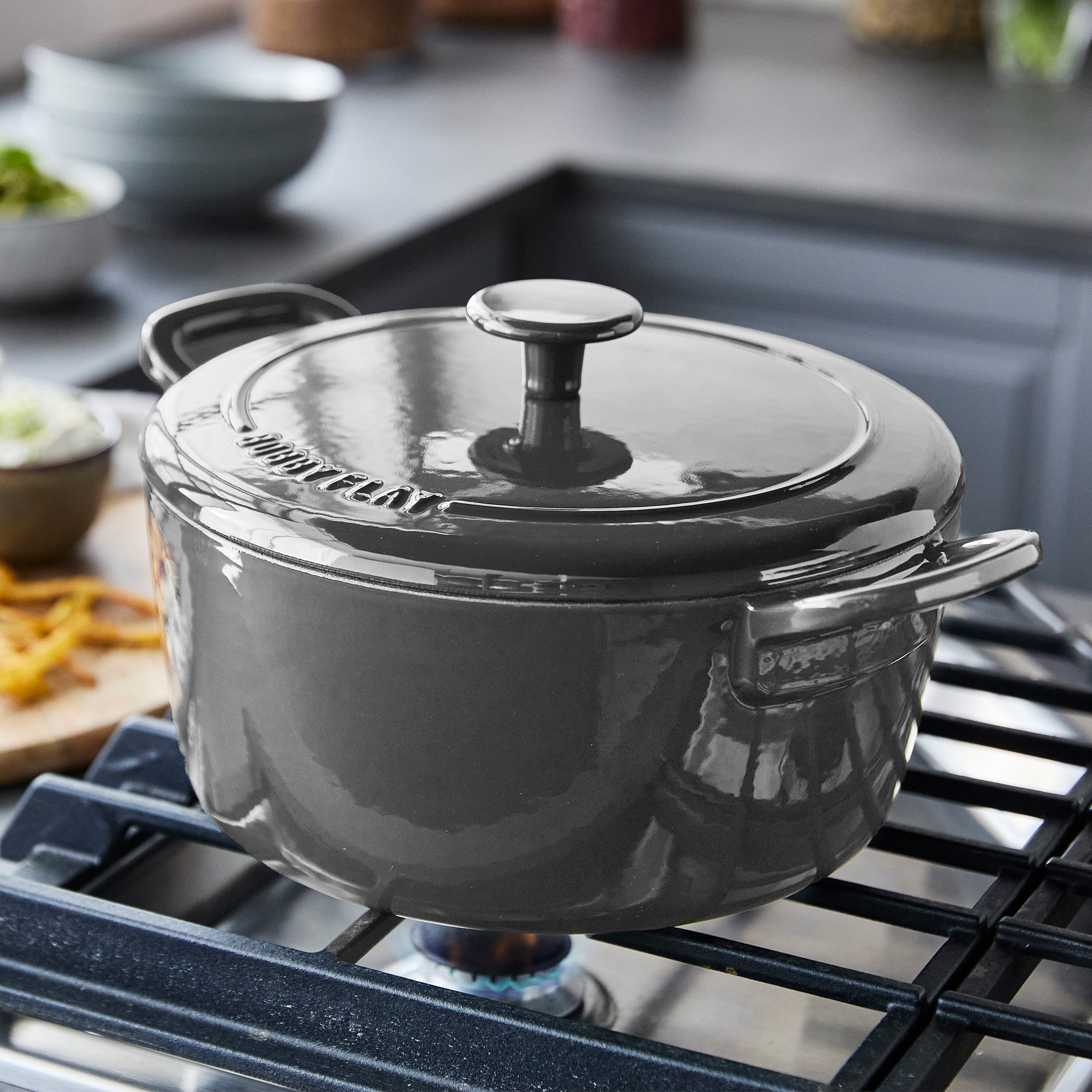 Slate-colored Dutch oven 3-piece set with GreenPan branding, ceramic material, shown on a modern kitchen stovetop.