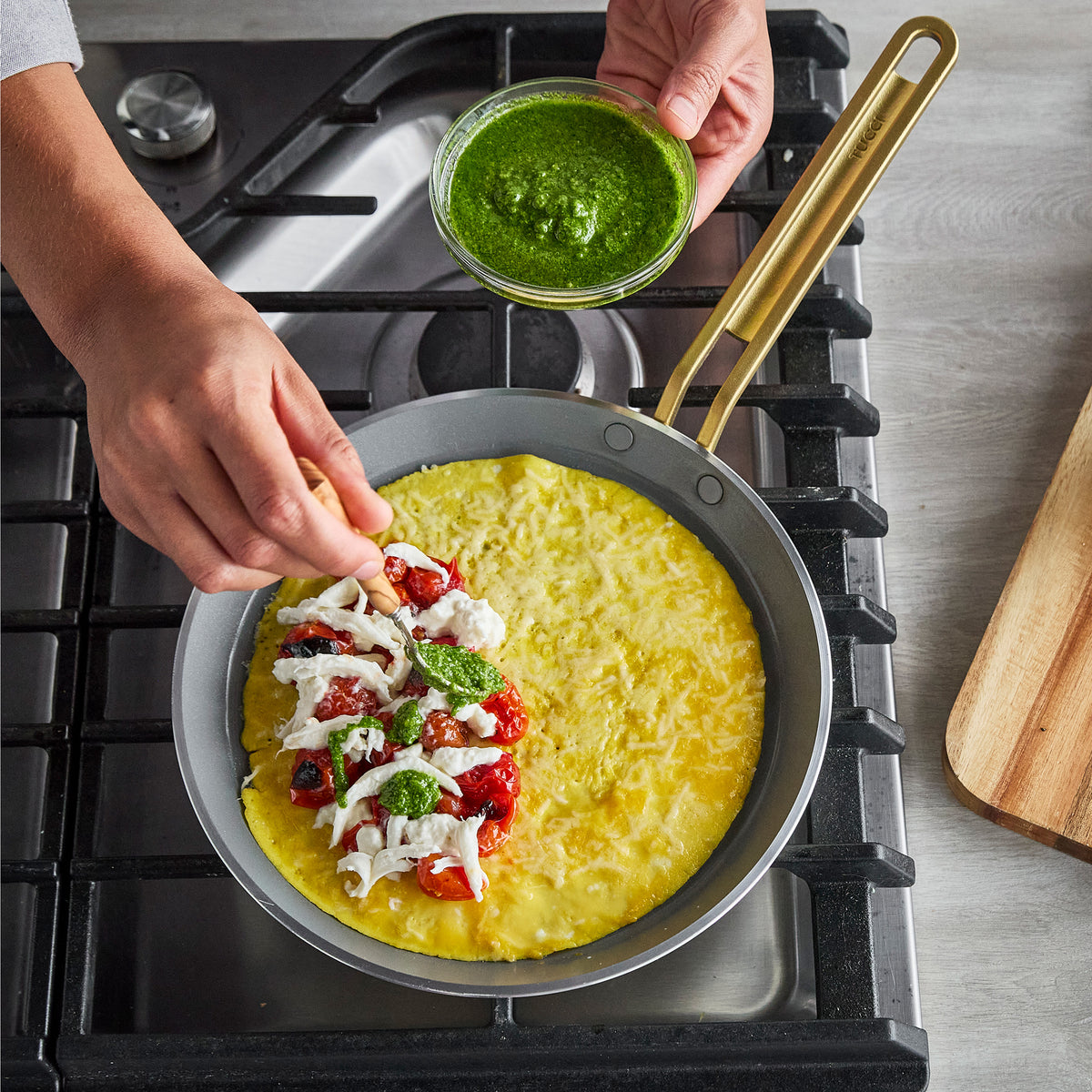 Stanley Tucci 10-inch ceramic nonstick crepe and omelette pan in espresso on a stovetop with a pesto-topped omelette.