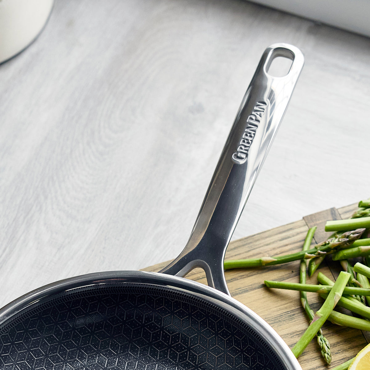 Hybrid ceramic nonstick 10-inch frypan next to a pile of cut green beans on a kitchen surface.