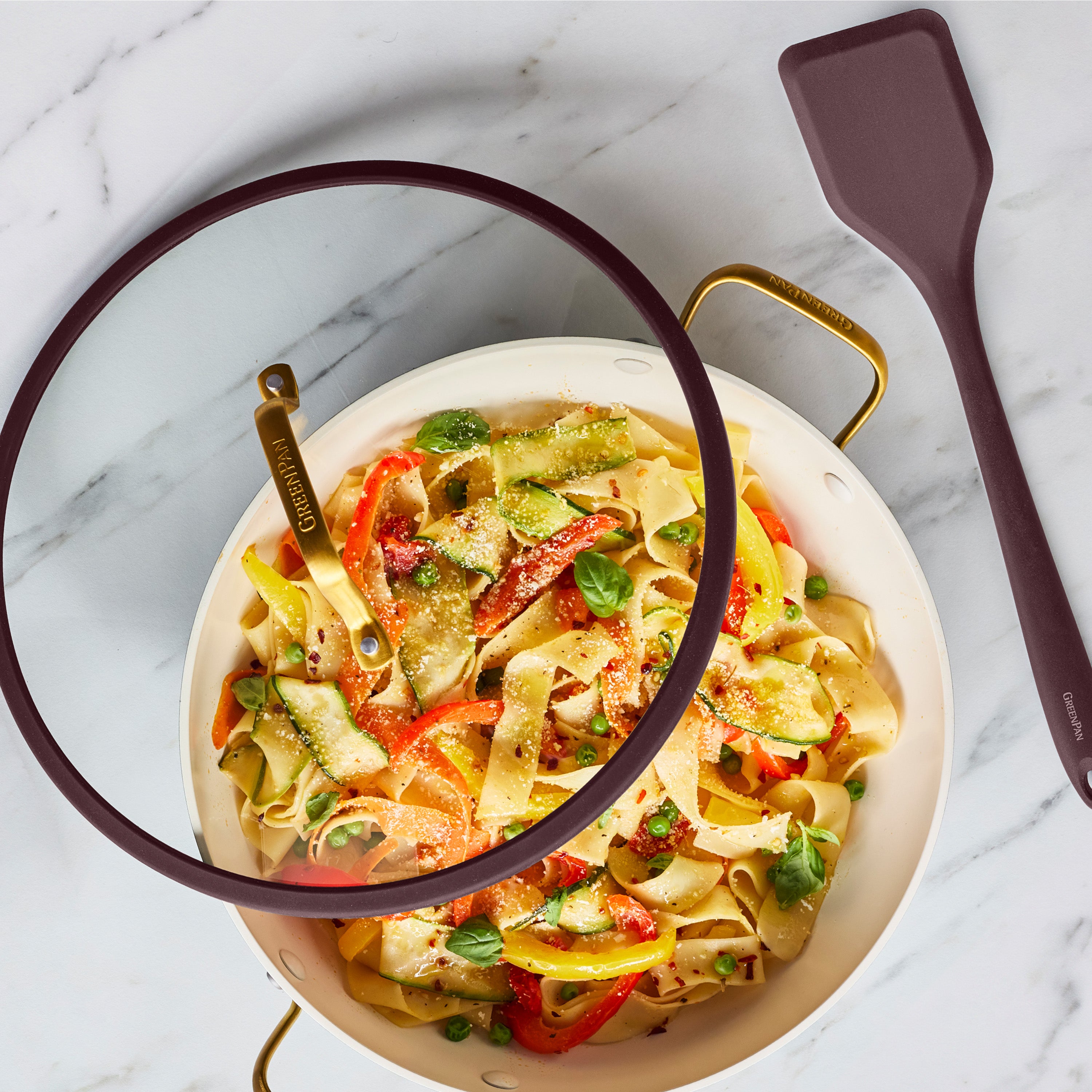 Bordeaux Reserve Pro Ceramic Nonstick 3.75-qt pan with lid, filled with tagliatelle and vegetables, on a marble surface.