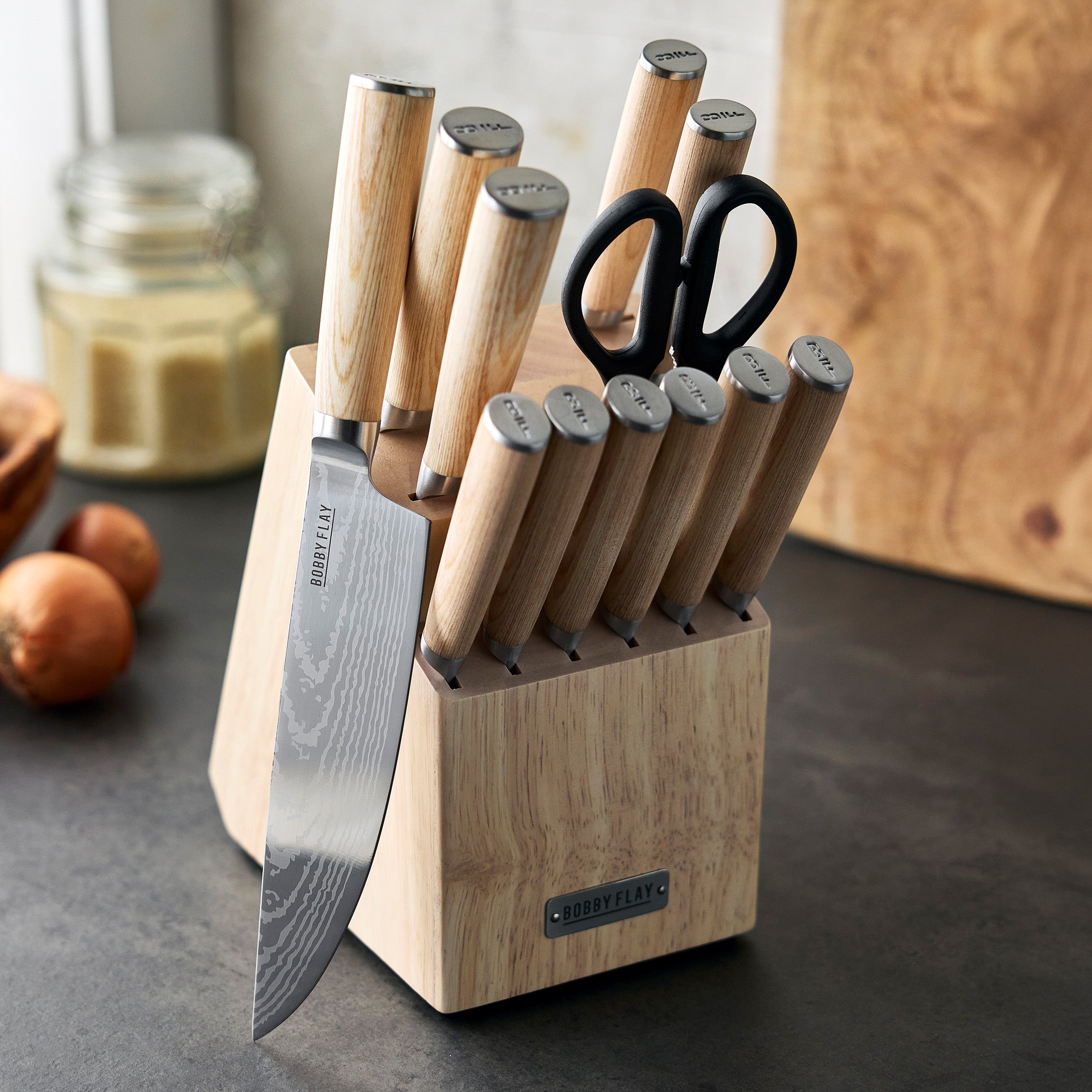 Set of knives with wood print handles in a block on a kitchen counter.
