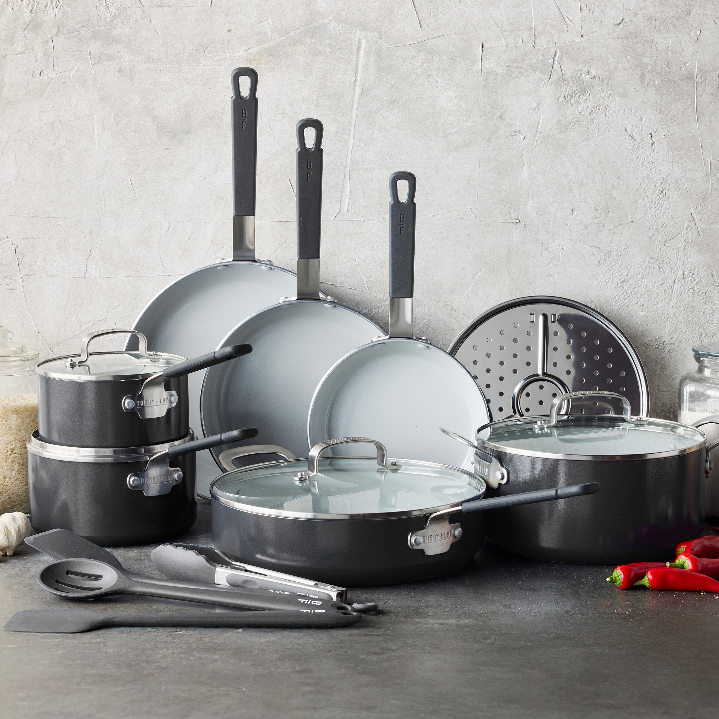 16-piece graphite ceramic cookware set on a kitchen counter with a gray background.