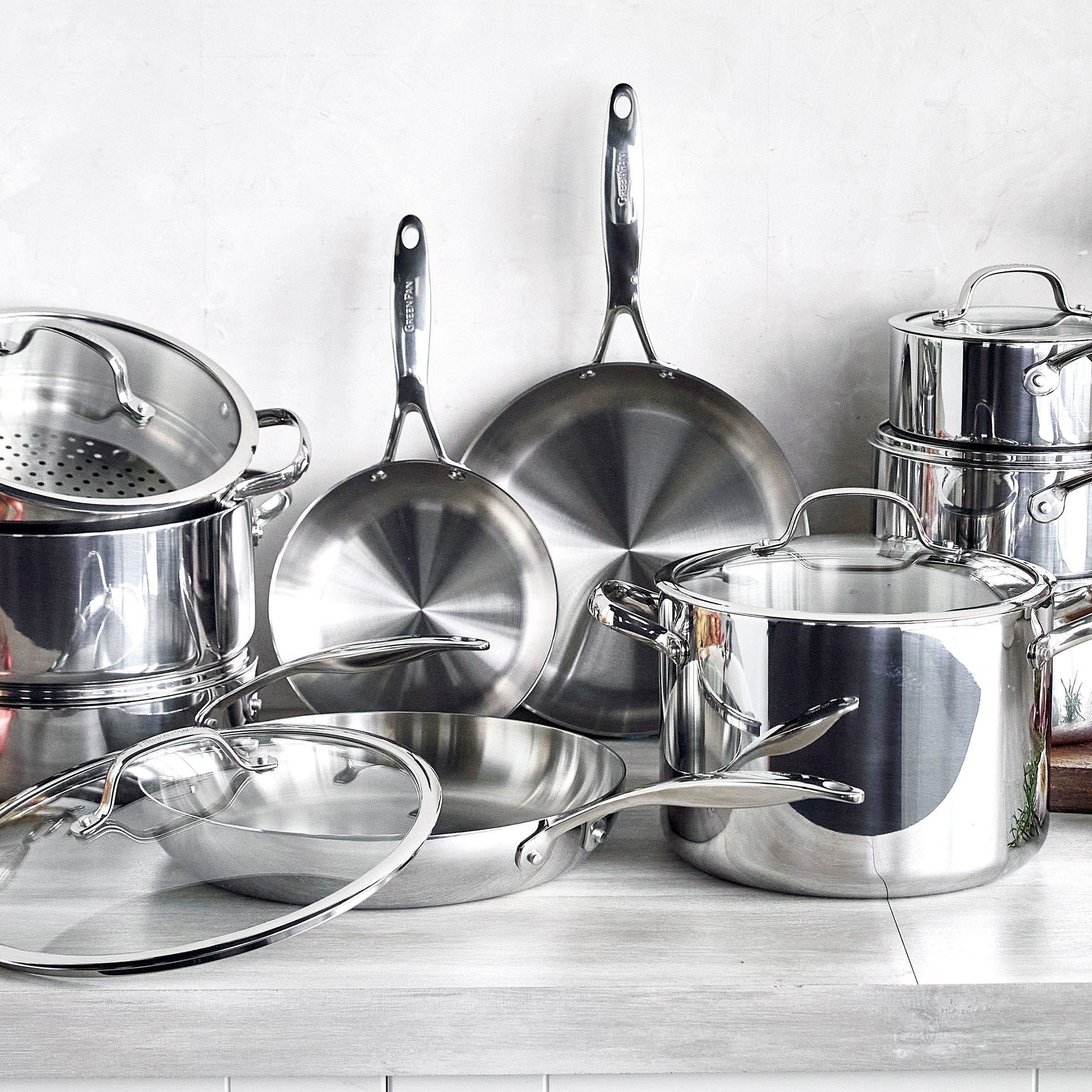 Set of stainless steel cookware on a light background