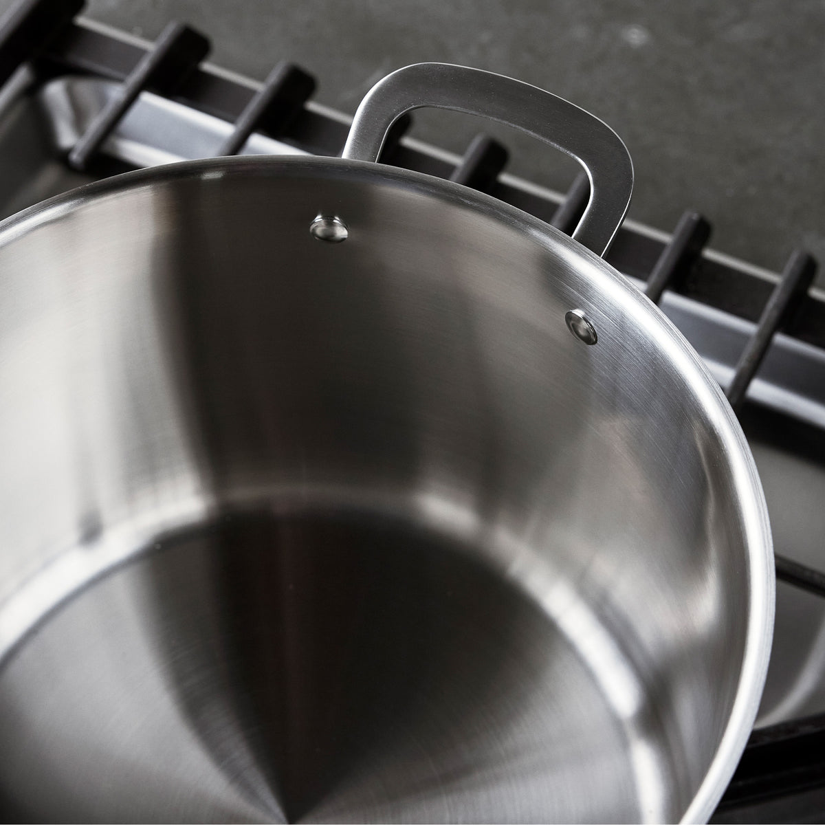 Bobby Flay by GreenPan 12-quart uncoated stainless steel stockpot on a stovetop grate.