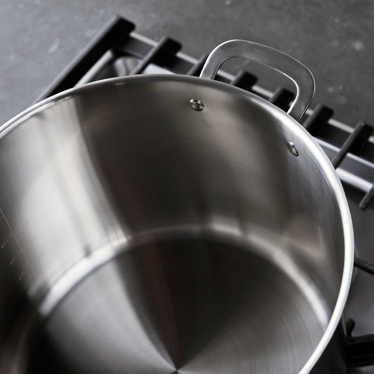 Bobby Flay by GreenPan 16-quart uncoated stainless steel stockpot with lid on a stovetop.