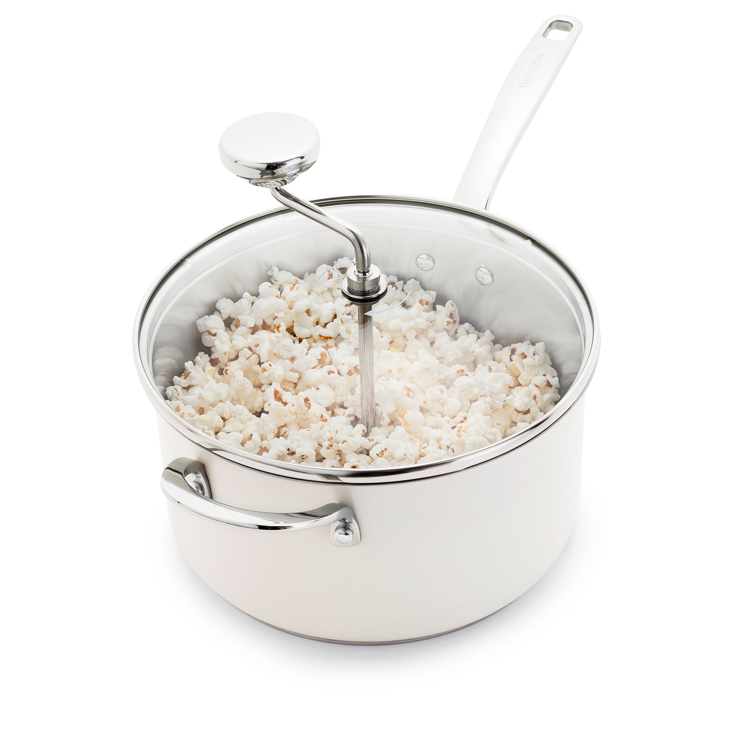 Cream popcorn maker with hand crank, filled with popped popcorn, set on a white surface.